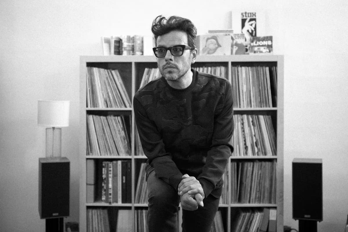 Clemente Castillo sitting in front of vinyl record collection